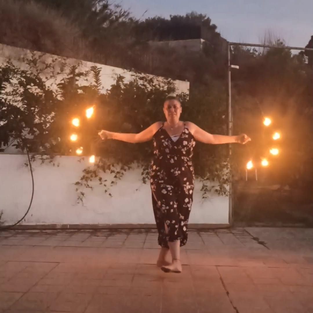 Miryam bailando con los abanicos de fuego en su primera clase de baile con fuego