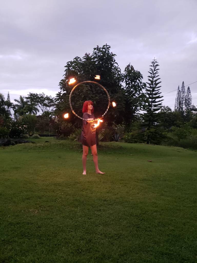 Alumna bailando con el hula hoop de fuego durante la clase impartida por Maka